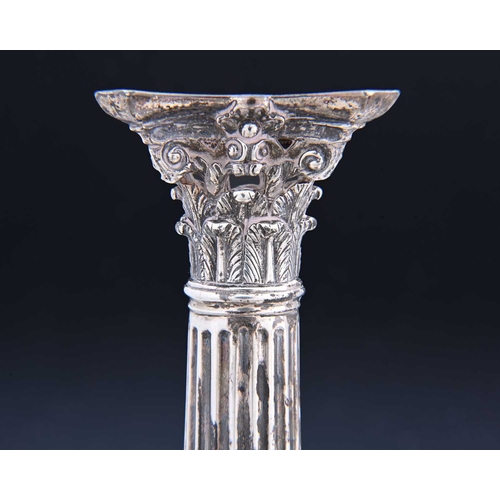 16 - A set of four early George III silver candlesticks, each on a filled square base chased with flowerh... 