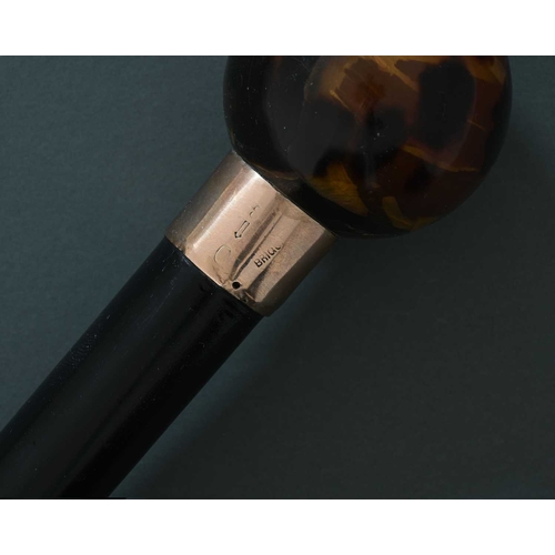 5 - Brigg of London. A nine-carat gold mounted walking cane, with ebonised shaft, and mottled resin type... 