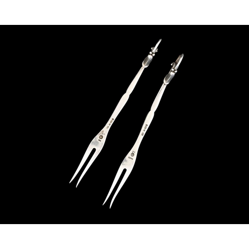 65 - Georg Jensen. A matched pair of silver Georg Jensen blossom forks, also struck with British import m... 