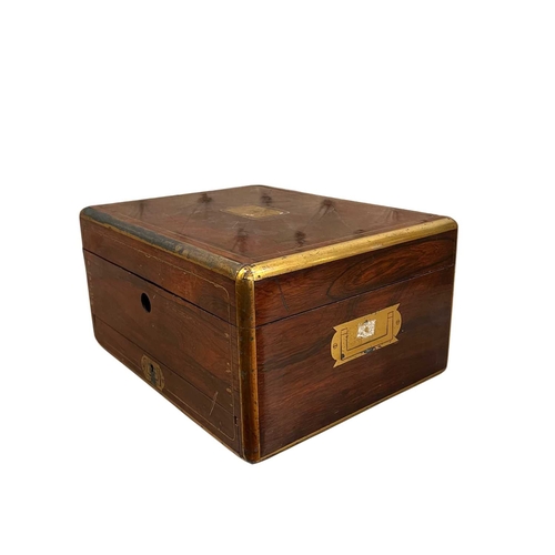 75 - An early Victorian rosewood and brass bound dressing case, the brass lift-out carrying handles to ei... 