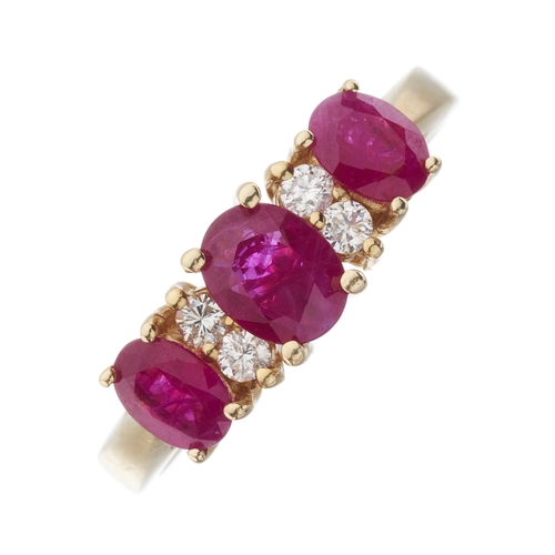 172 - A 14ct gold graduated oval-shape ruby three-stone dress ring, with brilliant-cut diamond double spac... 