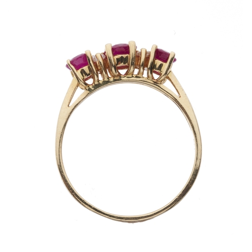 172 - A 14ct gold graduated oval-shape ruby three-stone dress ring, with brilliant-cut diamond double spac... 