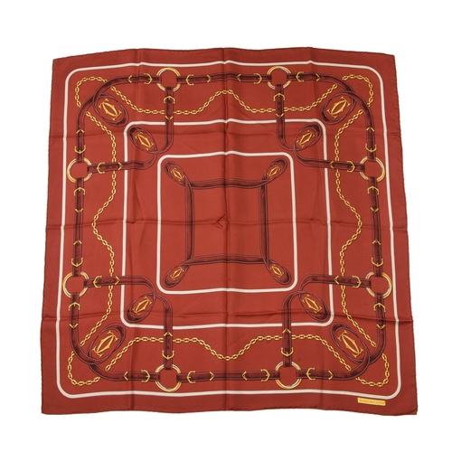 309 - Cartier, a Must De Cartier silk scarf, decorated with gold-tone chains and belt straps linked togeth... 