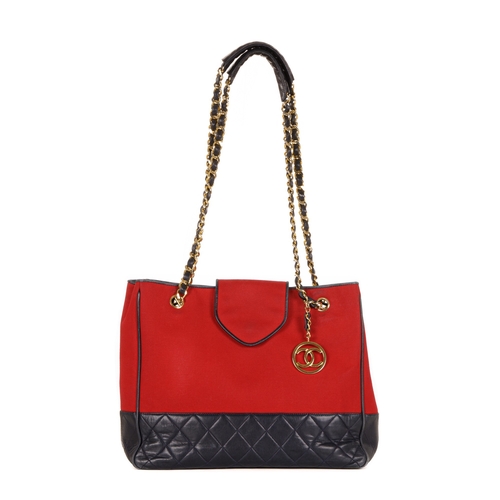 330 - Chanel, a Bicolour CC Charm tote, designed with a red canvas exterior with a quilted navy blue leath... 