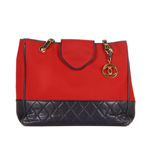 330 - Chanel, a Bicolour CC Charm tote, designed with a red canvas exterior with a quilted navy blue leath... 