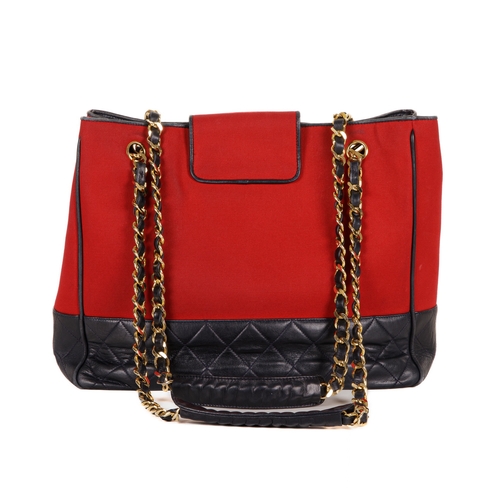 330 - Chanel, a Bicolour CC Charm tote, designed with a red canvas exterior with a quilted navy blue leath... 