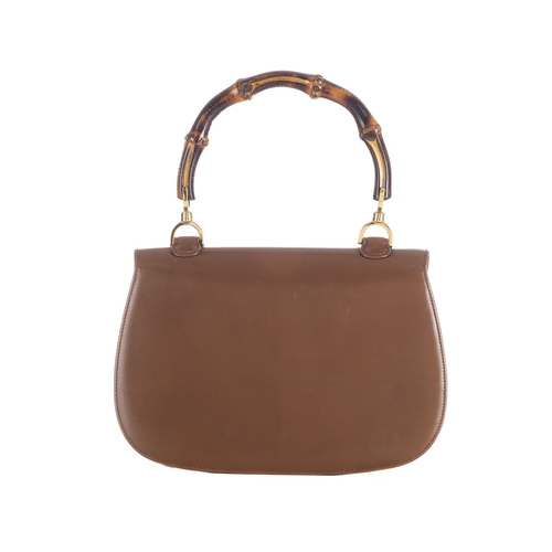 377 - Gucci, a vintage Bamboo Top Handle handbag, crafted from smooth tan leather, featuring a curved bamb... 