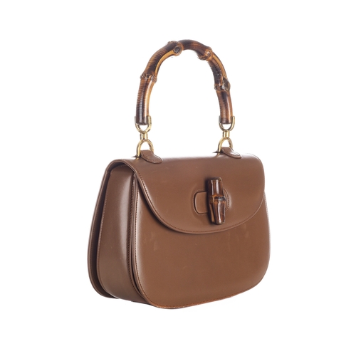 377 - Gucci, a vintage Bamboo Top Handle handbag, crafted from smooth tan leather, featuring a curved bamb... 