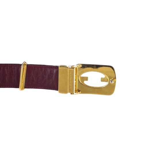 384 - Gucci, a vintage belt, the smooth black belt, with a burgundy leather underside and gold-tone GG pin... 