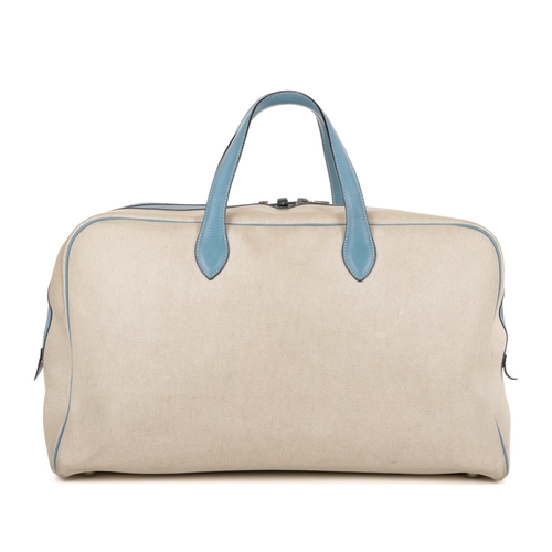 391 - Hermes, a 2000 toile Victora GM 50 travel bag, crafted from cream toile canvas with blue leather tri... 