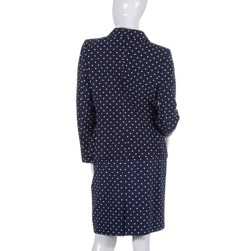 488 - Yves Saint Laurent, a navy blue and white polka dot skirt suit, comprising a fitted jacket with fron... 