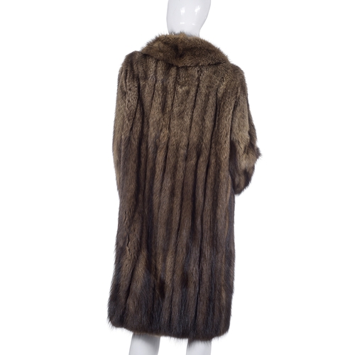 510 - A knee-length raccoon fur coat, fully stranded, featuring a notched lapel collar, hook and eye faste... 