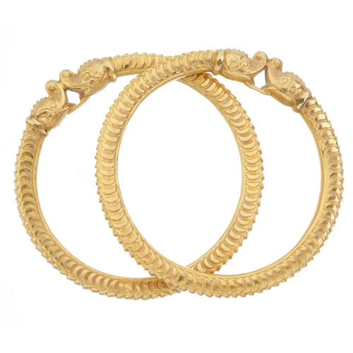 54 - Two 18ct gold double zoomorphic dog bangles, each designed as a stylised fish, inner diameter 5.8cm,... 