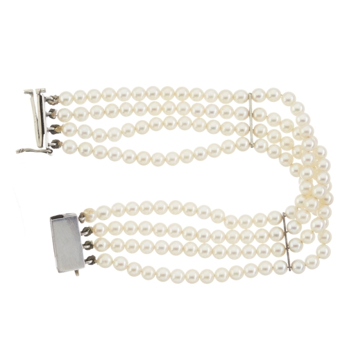 81 - A mid 20th century pearl four-row bracelet, with white metal pearl accent sliding clasp and bar spac... 