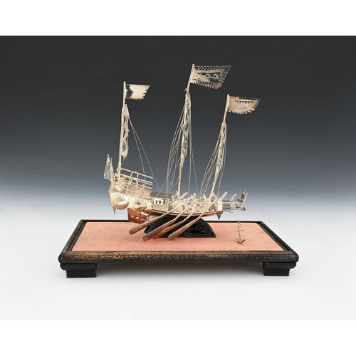 135 - A Chinese silver-coloured metal model of a sailing ship or a junk, ensuite with rigging and sails, w... 