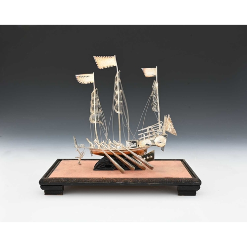 135 - A Chinese silver-coloured metal model of a sailing ship or a junk, ensuite with rigging and sails, w... 