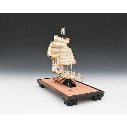 135 - A Chinese silver-coloured metal model of a sailing ship or a junk, ensuite with rigging and sails, w... 