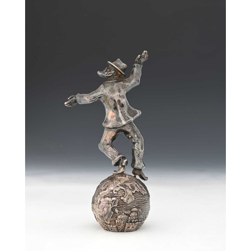 137 - Judaica, a twentieth-century silver-coloured metal figure, atop a sphere decorated in relief, inscri... 