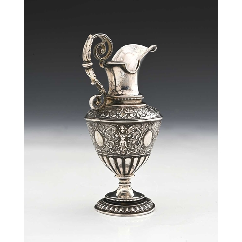 138 - A Continental silver-coloured metal ewer or jug, modelled in the classical form, the body decorated ... 