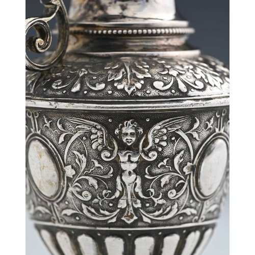 138 - A Continental silver-coloured metal ewer or jug, modelled in the classical form, the body decorated ... 