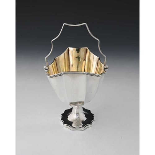 156 - A George III silver swing handle basket, of panelled oval form, atop a waisted stem with spreading f... 