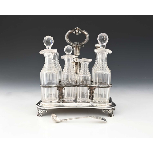 172 - A William IV silver condiment set, seven cut glass bottles, the silver stand of shaped rectangular f... 