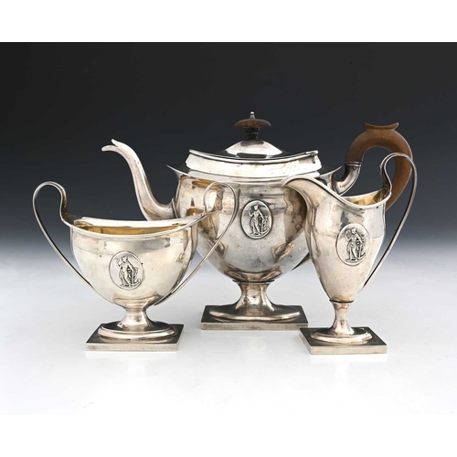 176 - An Edwardian silver three-piece tea set, comprising teapot with wood handle and finial, milk jug, an... 