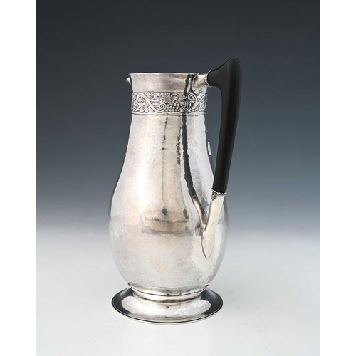 222A - George Hart for the Guild of Handicraft, an Arts and Crafts silver wine jug, London 1908, planished,... 