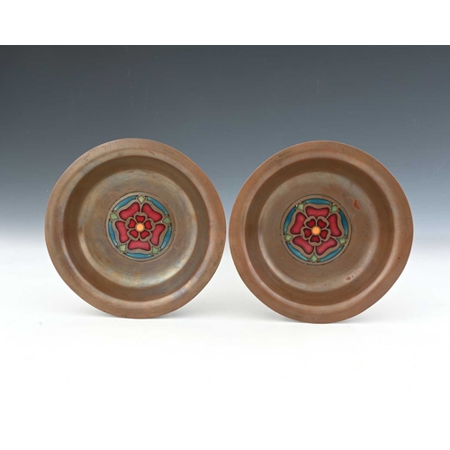 258A - A pair of Arts and Crafts copper ane enamel dishes, circular for with everted rims, set with central... 