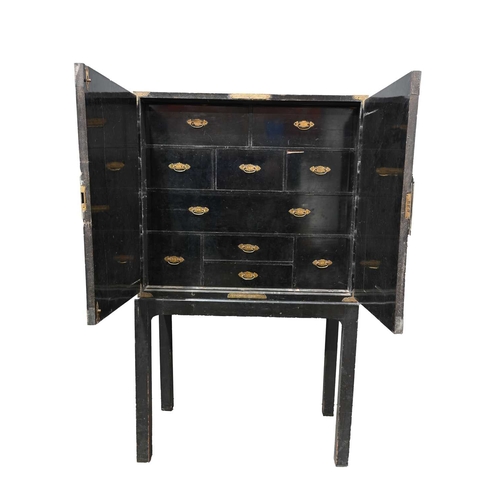 369 - A Chinese export black lacquer cabinet on stand, Qing dynasty, chinoiserie decorated with extensive ... 