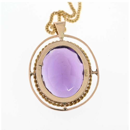 46 - An early 20th century 9ct gold amethyst pendant, within a rope-twist border and polished halo surrou... 