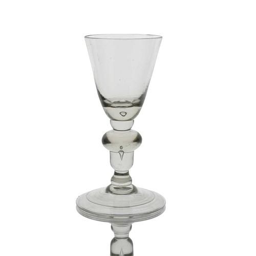 633 - An acorn knopped heavy baluster wine glass, circa 1715, the conical bowl with air bubble inclusion t... 