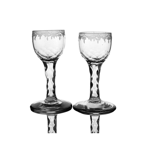 638 - A set of four facet cut wine glasses, circa 1775, the ogee bowls engraved with festooned swag border... 