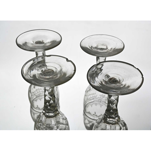 638 - A set of four facet cut wine glasses, circa 1775, the ogee bowls engraved with festooned swag border... 