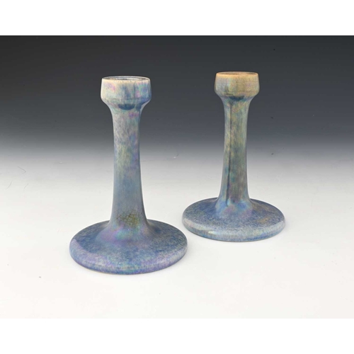 734 - Ruskin Pottery, a pair of lavender Lustre candlesticks, 1925, splayed form with poppy head sconces, ... 