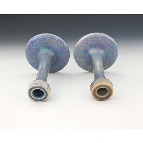 734 - Ruskin Pottery, a pair of lavender Lustre candlesticks, 1925, splayed form with poppy head sconces, ... 