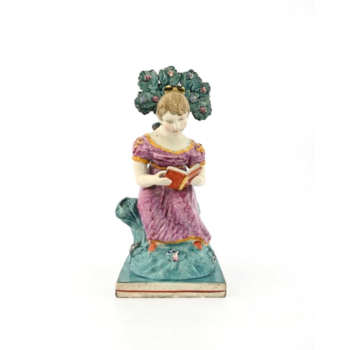 857 - An Obadiah Sherratt Staffordshire figure of a girl reading, circa 1820, sitting on a tuffet with boc... 