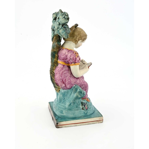 857 - An Obadiah Sherratt Staffordshire figure of a girl reading, circa 1820, sitting on a tuffet with boc... 