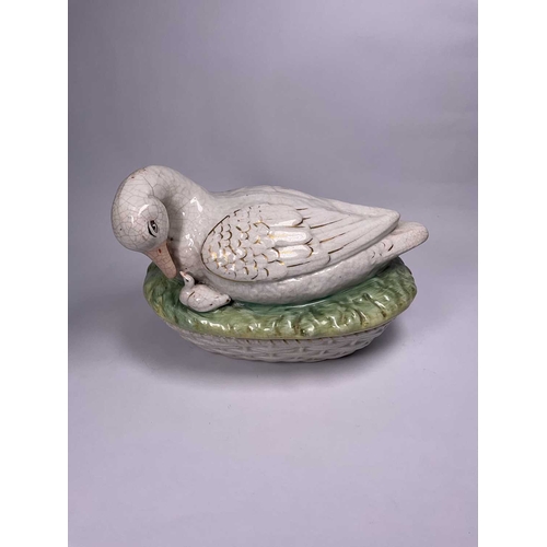 129 - A Staffordshire duck tureen and cover, the mother bird modelled bending her beak towards her young, ... 