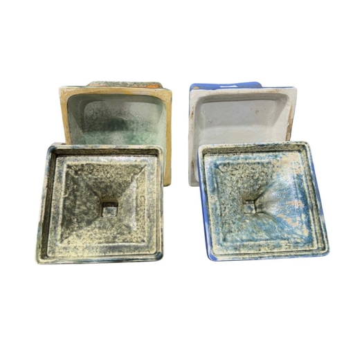 165 - Two Ruskin Pottery square form crystaline glazed biscuit barrels, marks to base, 18cm high (2)... 