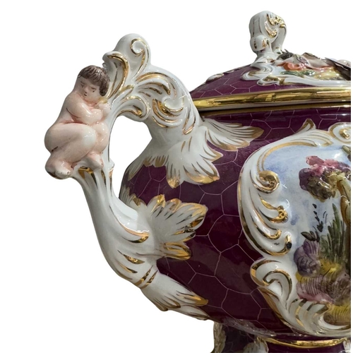 189 - A large two-handled burgundy ground Capodimonte tureen with lid, the body is decorated with gilded r... 