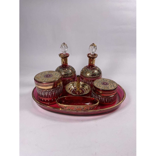 251 - WITHDRAWN
A pink glass gilded dressing table set with tubelined enamel floral decoration, oval tray ... 