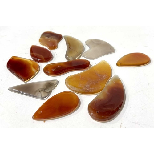 293 - A collection of Chinese agate pendants, purple grey ranging to oranges and reds, irregular forms (1 ... 