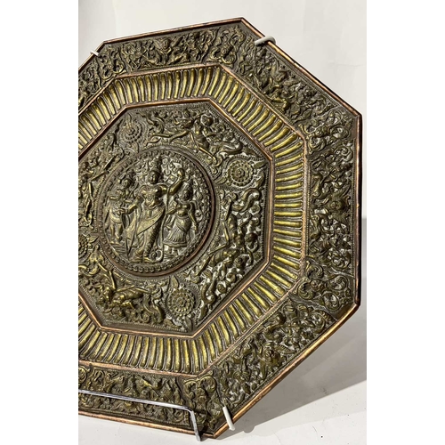 324 - An brass and copper octagonal form plaque or platter, 19th century, decorated with Buddhist iconogra... 