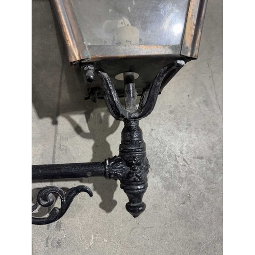 384 - Two 19th century French glazed copper street lanterns/lamps supported on foliate scrolled cast iron ... 