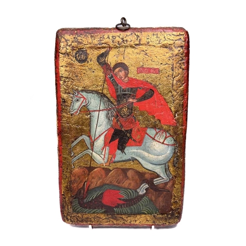 413 - A Greek Orthodox icon depicting St George and the vanquished dragon, hand painted with gilding on wo... 