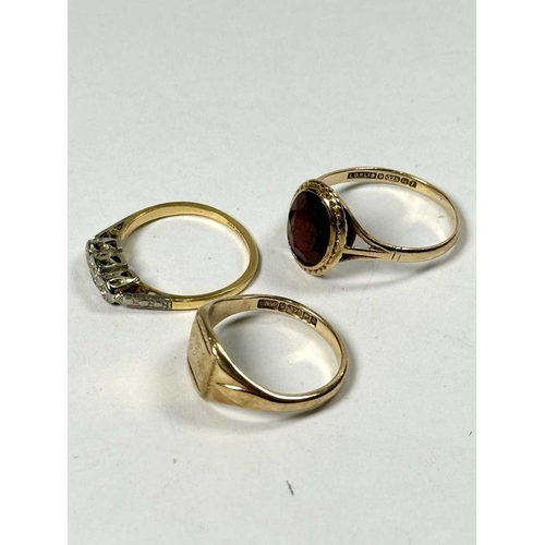 573 - Three gold rings, to include an 18ct gold diamond three-stone ring, all with hallmarks, ring sizes K... 