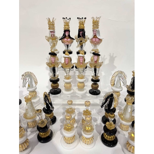 59 - A Murano glass chess set, figurative pieces worked in clear, white, black and gold foil-infused glas... 