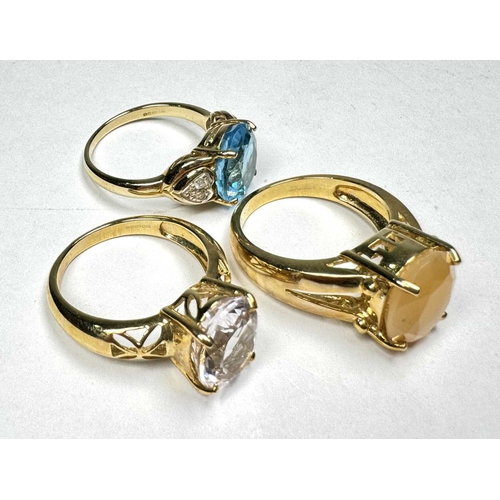 609 - Three gold coloured gem-set rings, gems to include moonstone, blue topaz, diamond and others, total ... 