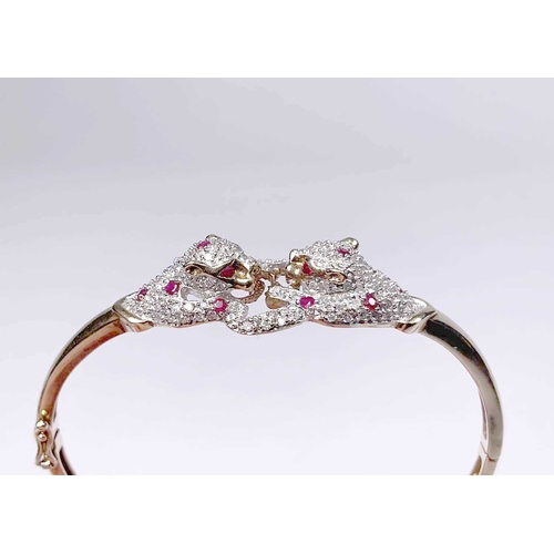 670 - A diamond and ruby panther bangle bracelet, estimated total diamond weight 0.60ct, stamped 9k, inner... 